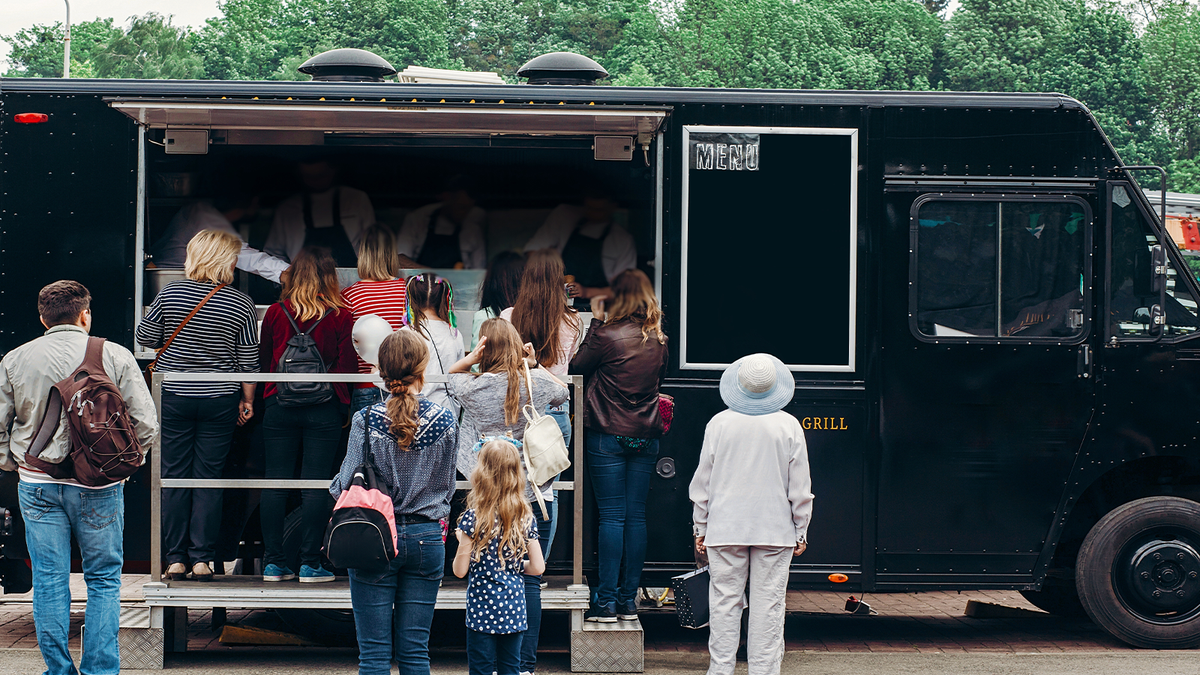 Alt text: "Food truck serving a line of customers, an example of a mobile business that needs reliable internet
