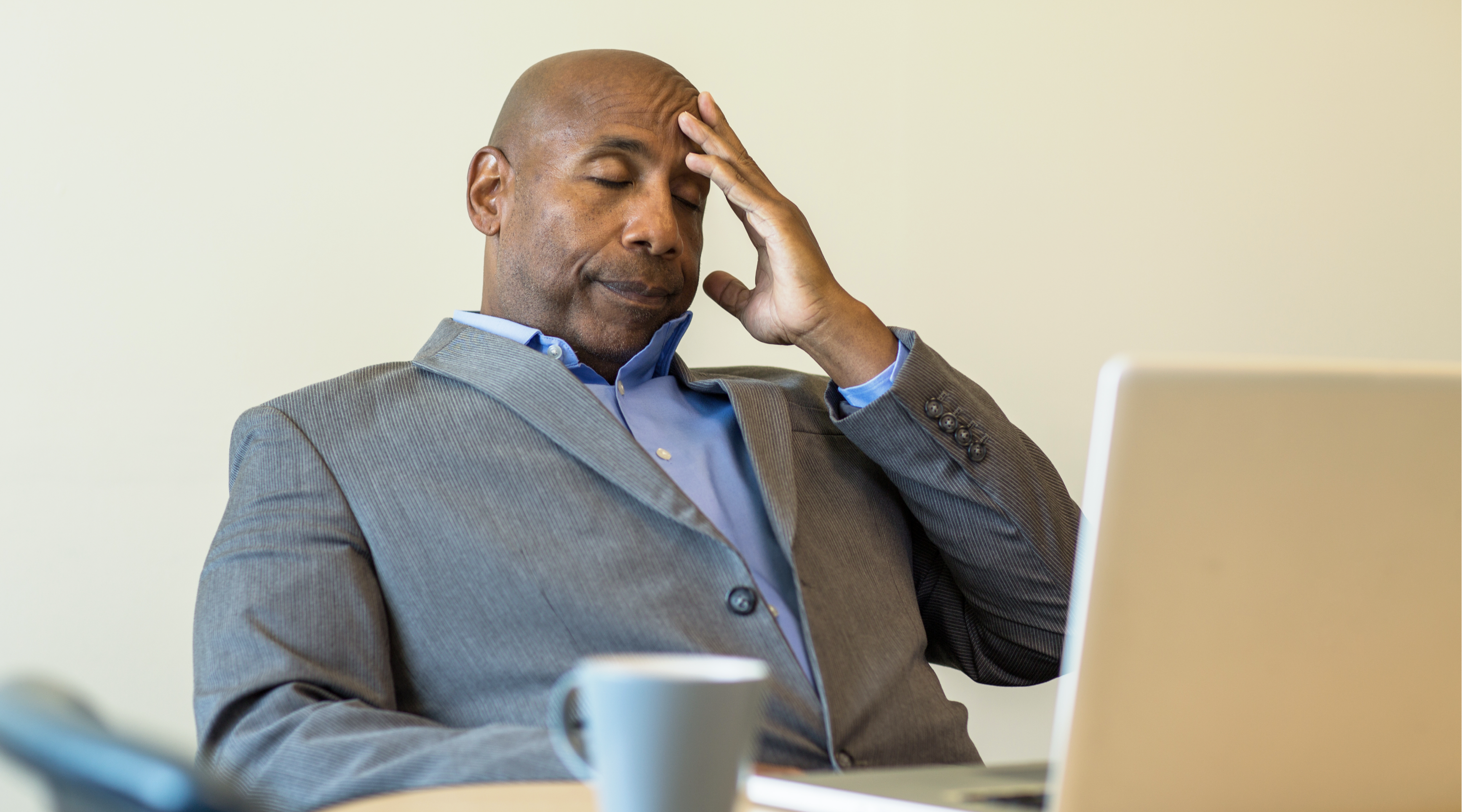 Professional working on a laptop with a frustrated expression, representing unreliable internet.