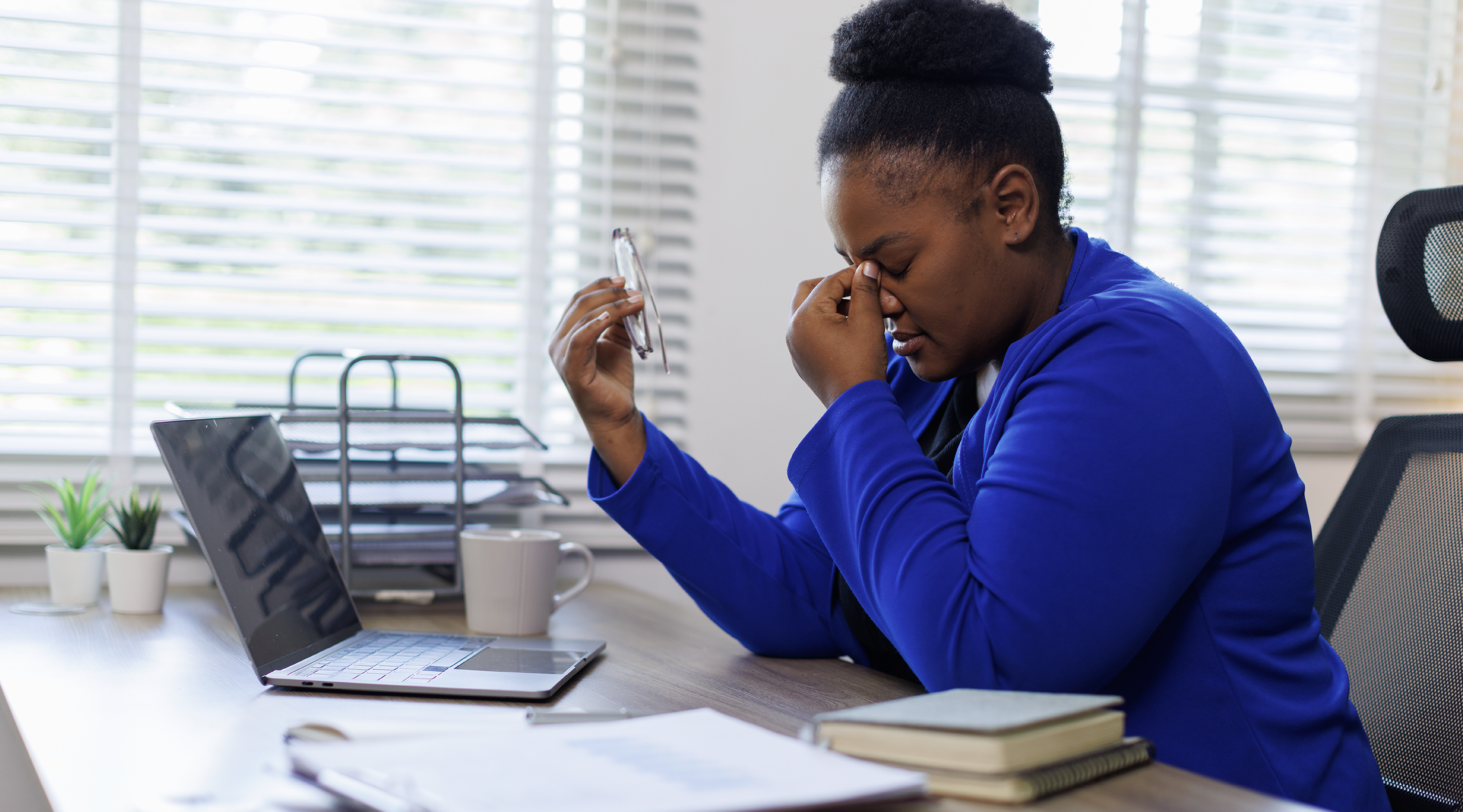 Business professional frustrated while working at a laptop due to unreliable technology.