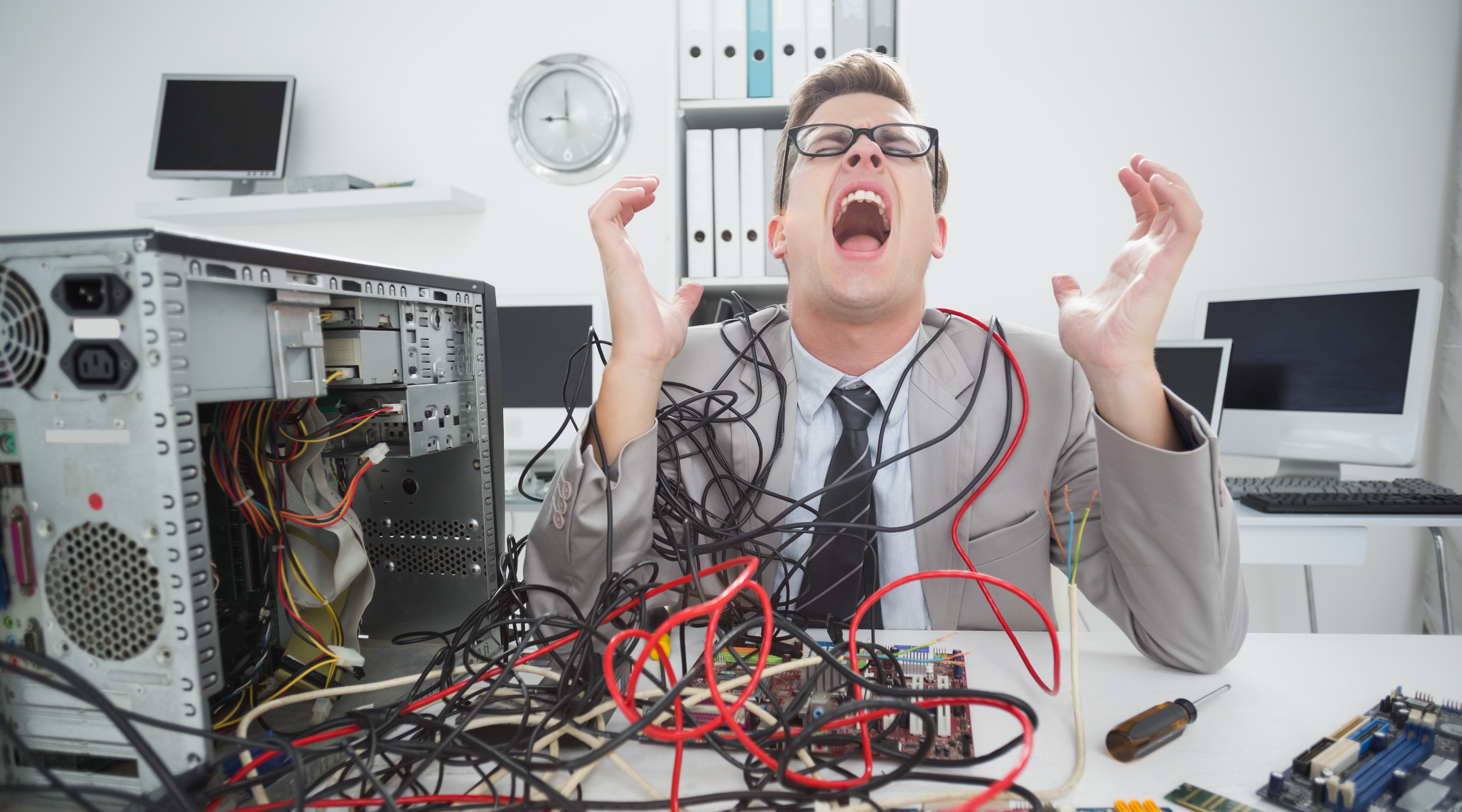 Frustrated IT professional dealing with tangled cables and unreliable networking equipment in an office.