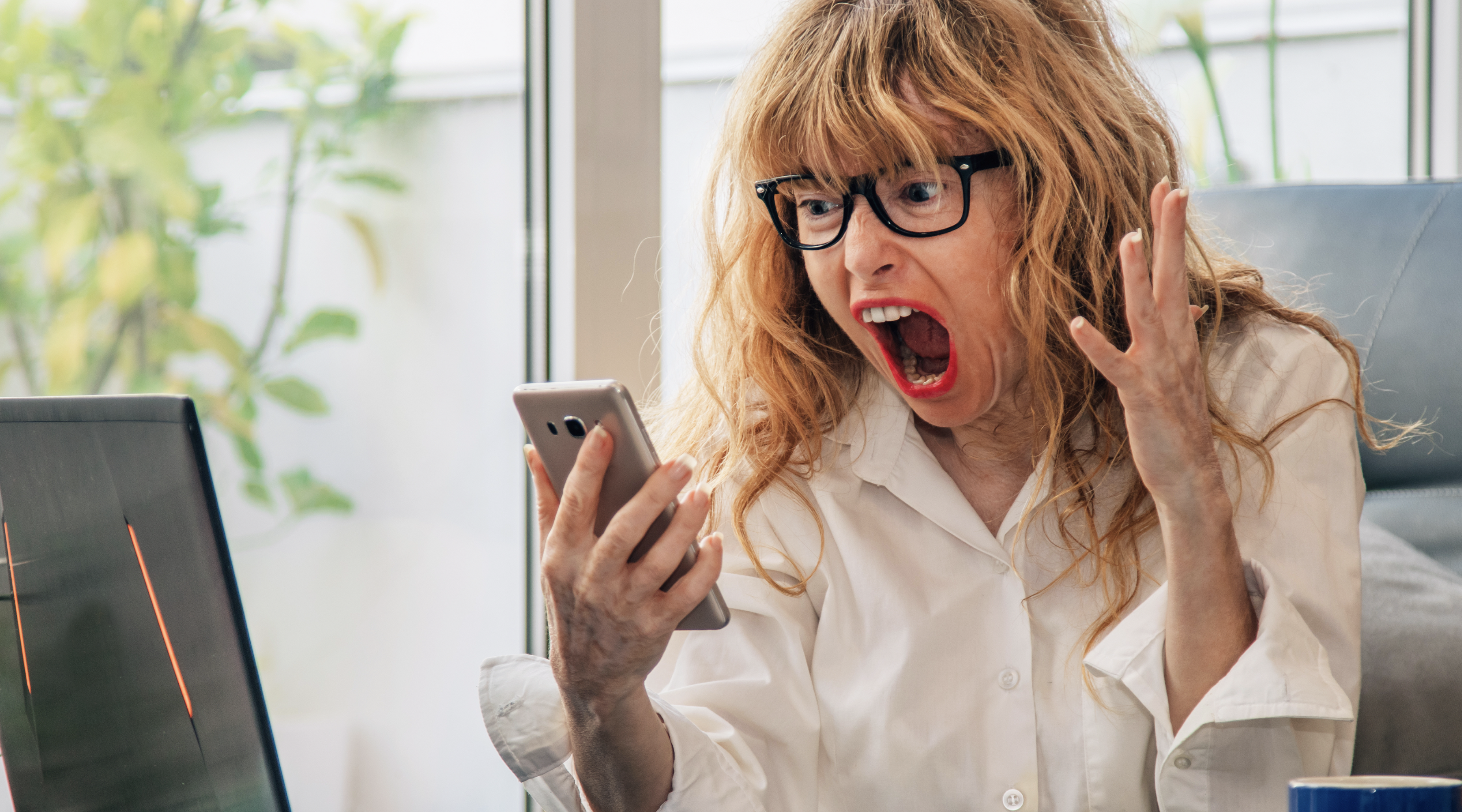 Person reacting to a mobile notification, representing remote property monitoring with the Katalyst Hawk solar-powered cellular camera.