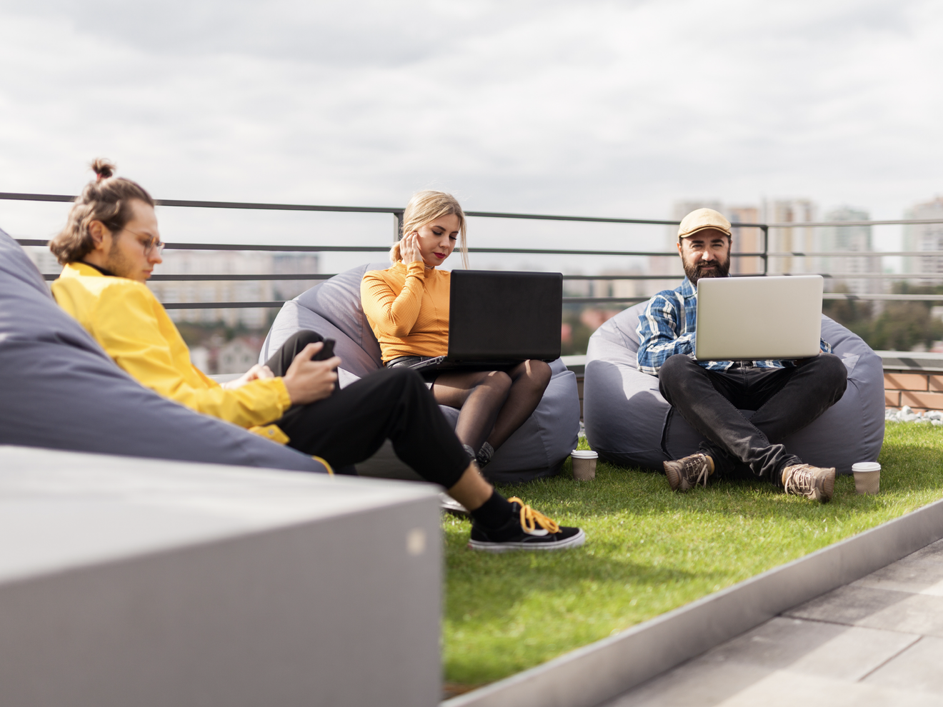 People working on laptops with extended Wi-Fi coverage across a large indoor and outdoor workspace.