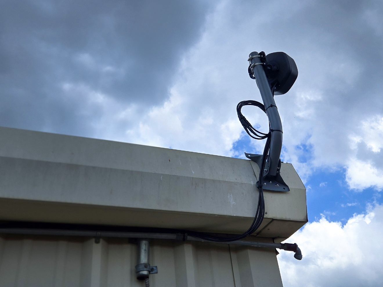 Siren outdoor cellular antenna mounted on a building, showcasing flexible installation options for walls, poles, and other fixed structures.