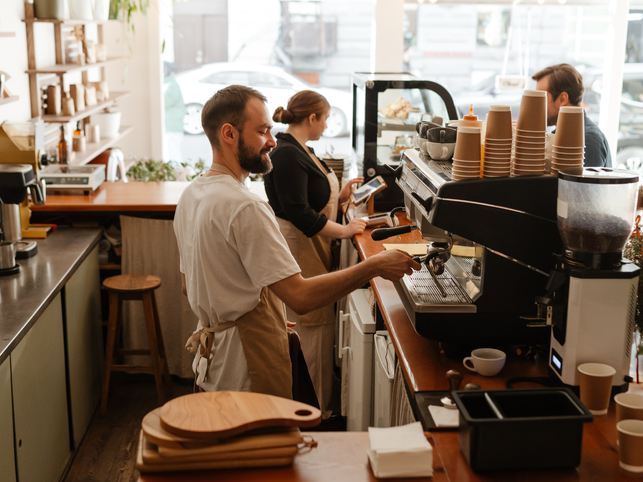 Employees preparing drinks behind the counter of a retail business.