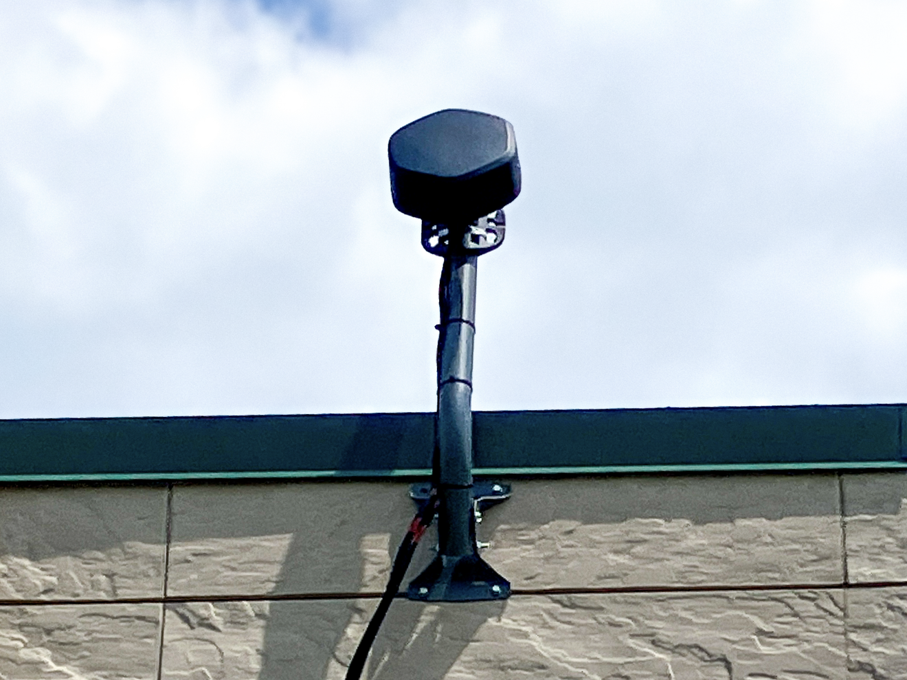 Siren ultra-wideband outdoor antenna mounted on a building, providing reliable cellular connectivity and high-performance coverage for 2G, 5G, LTE, CAT-M, and NB-IoT applications.