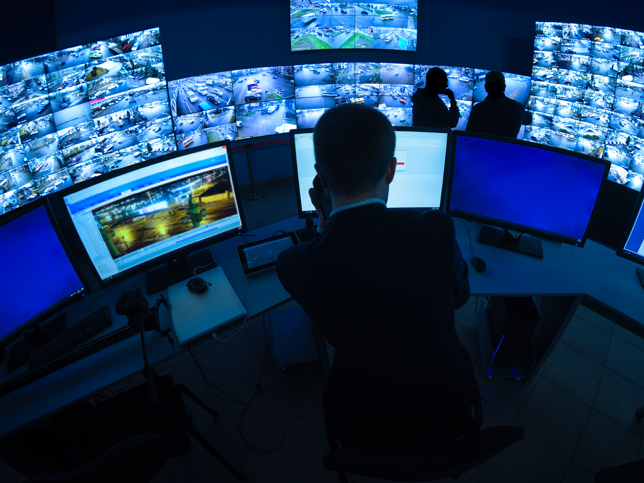 Security operations center monitoring multiple camera feeds across a large facility using cellular-connected monitoring systems.