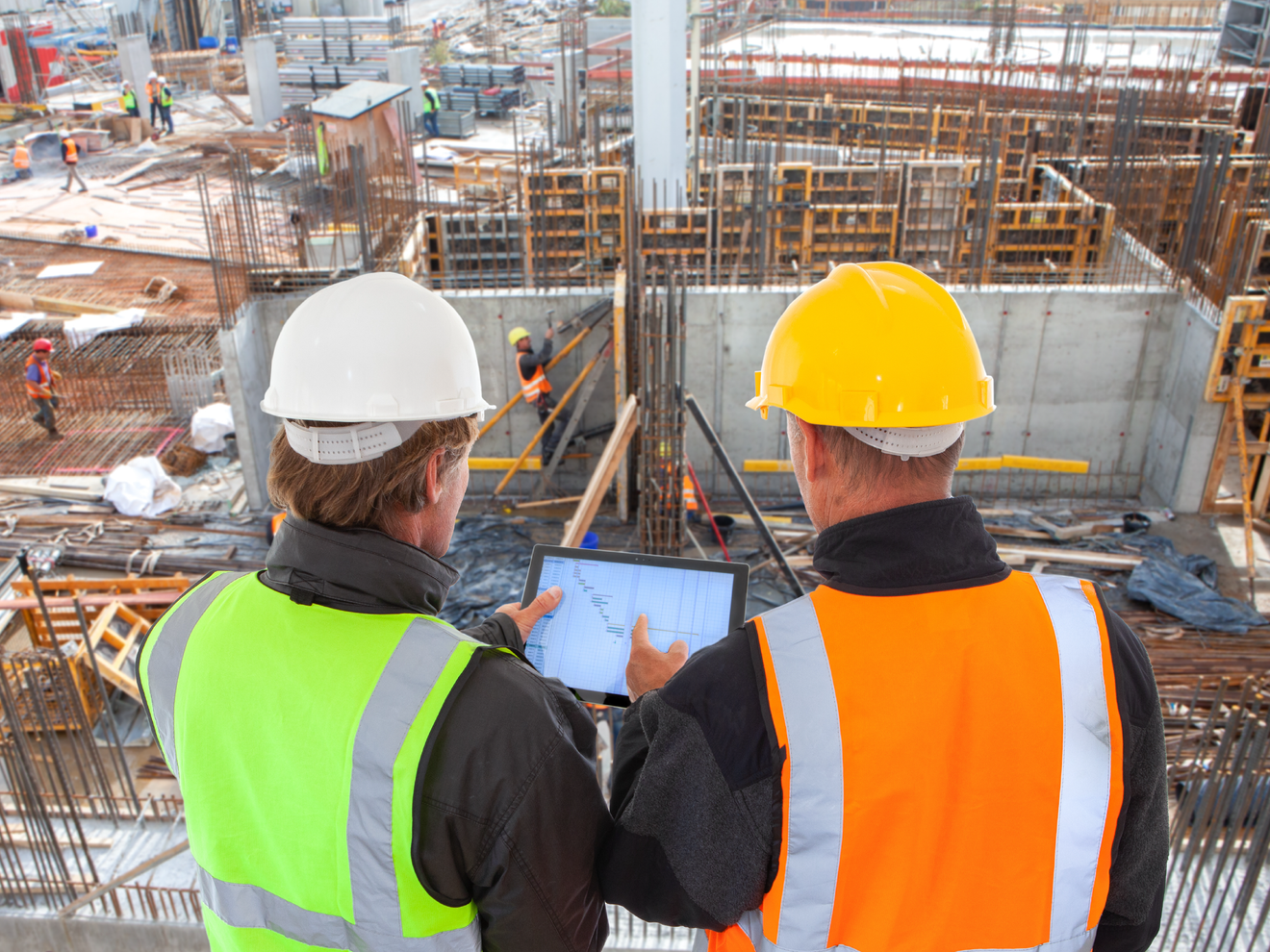 Construction managers using tablets on an active job site with cellular internet for project connectivity